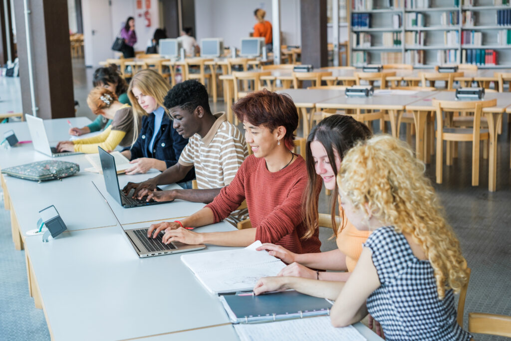 Students using laptops in a classroom, illustrating real-world device use and the need for extended warranty coverage beyond OEM plans in K-12 schools